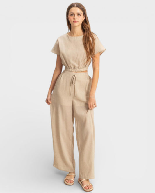 Woman wearing a beige jumpsuit on a white background