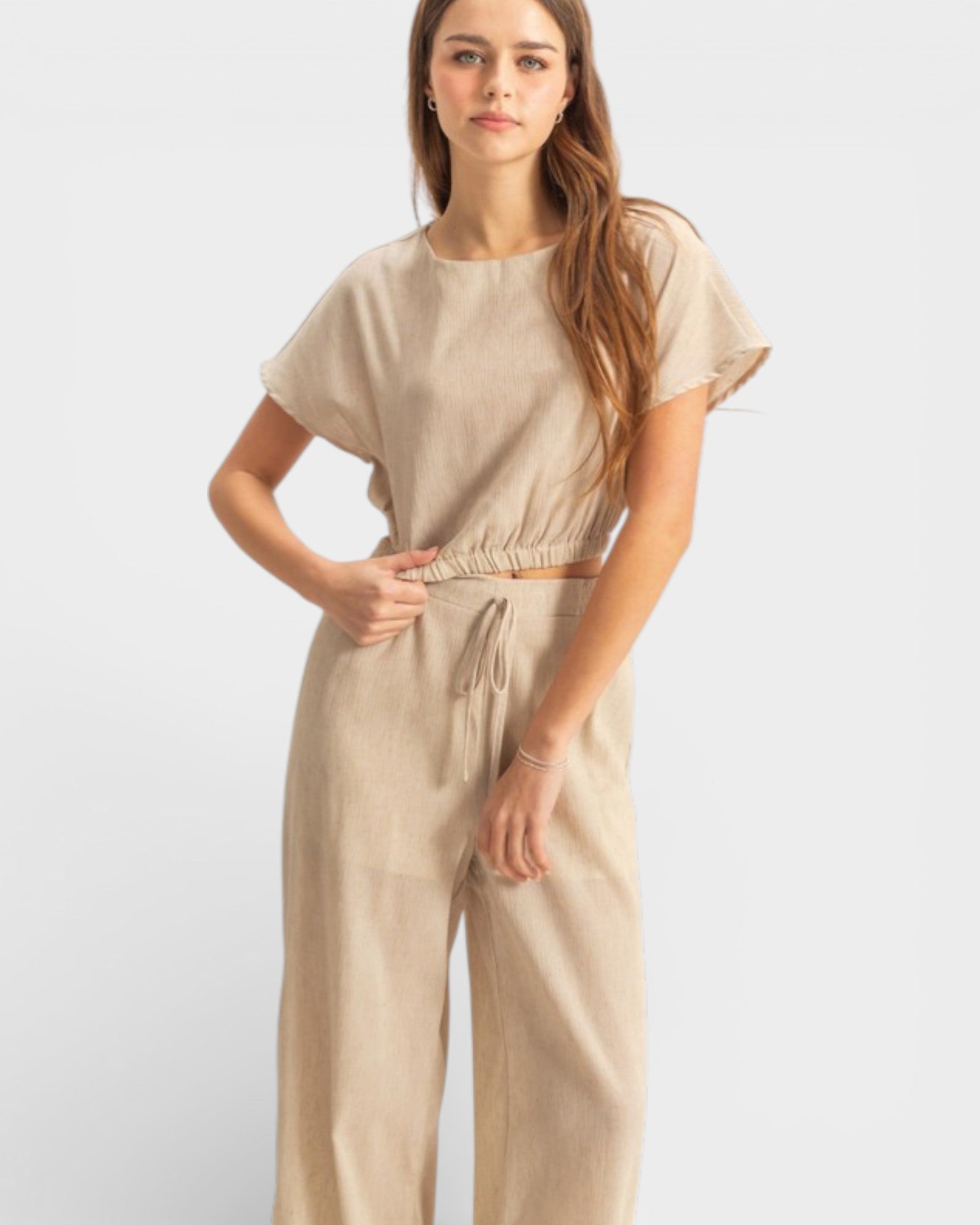 Woman wearing a beige outfit on a white background