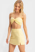 Woman wearing a yellow bikini set on a white background
