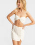 Woman wearing a white bikini set on a light gray background