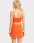 Woman wearing an orange two-piece outfit on a white background