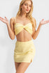 Woman wearing a yellow bikini set on a white background