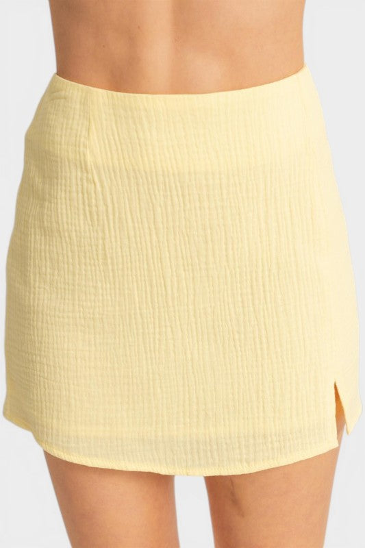 Yellow skirt worn by a person on a plain background