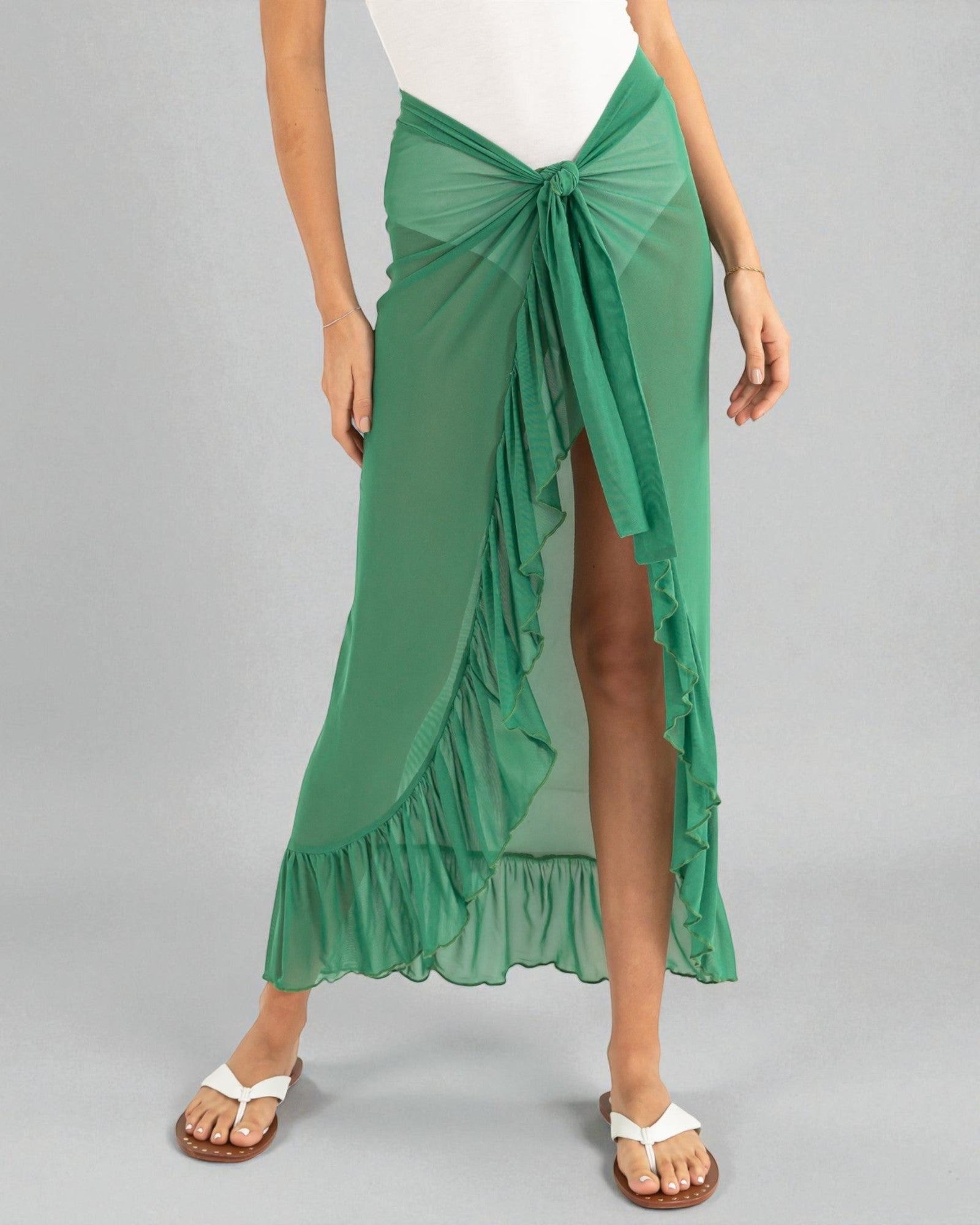 Green ruffled skirt worn by a person on a gray background