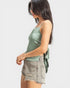 Woman wearing a green tank top and denim shorts on a white background