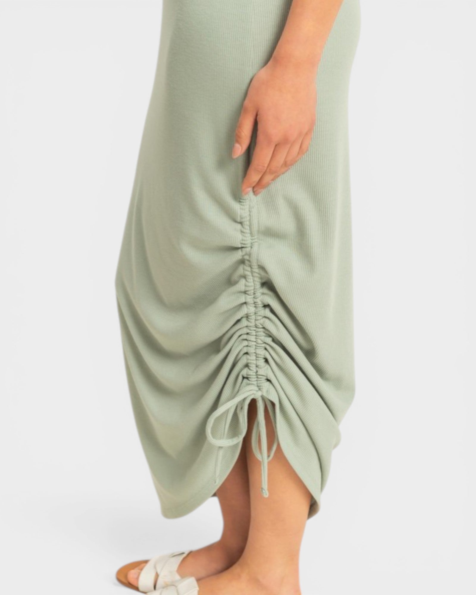 Sage green dress with ruched detail on a white background