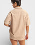 Person wearing a beige short-sleeve shirt on a light gray background