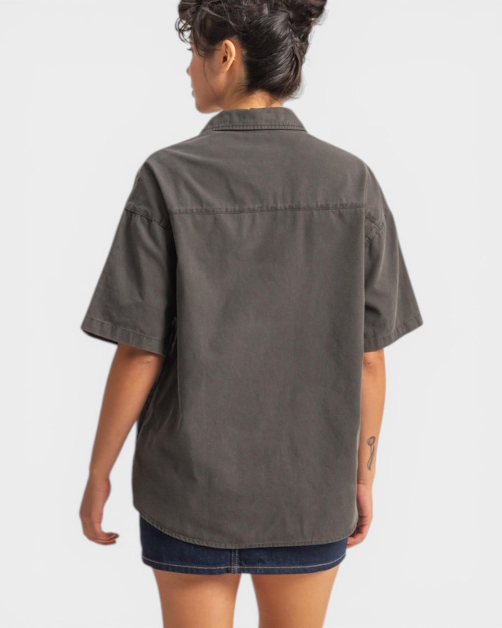 Person wearing a gray short-sleeve shirt on a white background