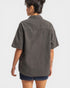 Person wearing a gray short-sleeve shirt on a white background