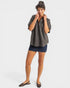 Woman wearing a gray shirt and denim skirt on a white background