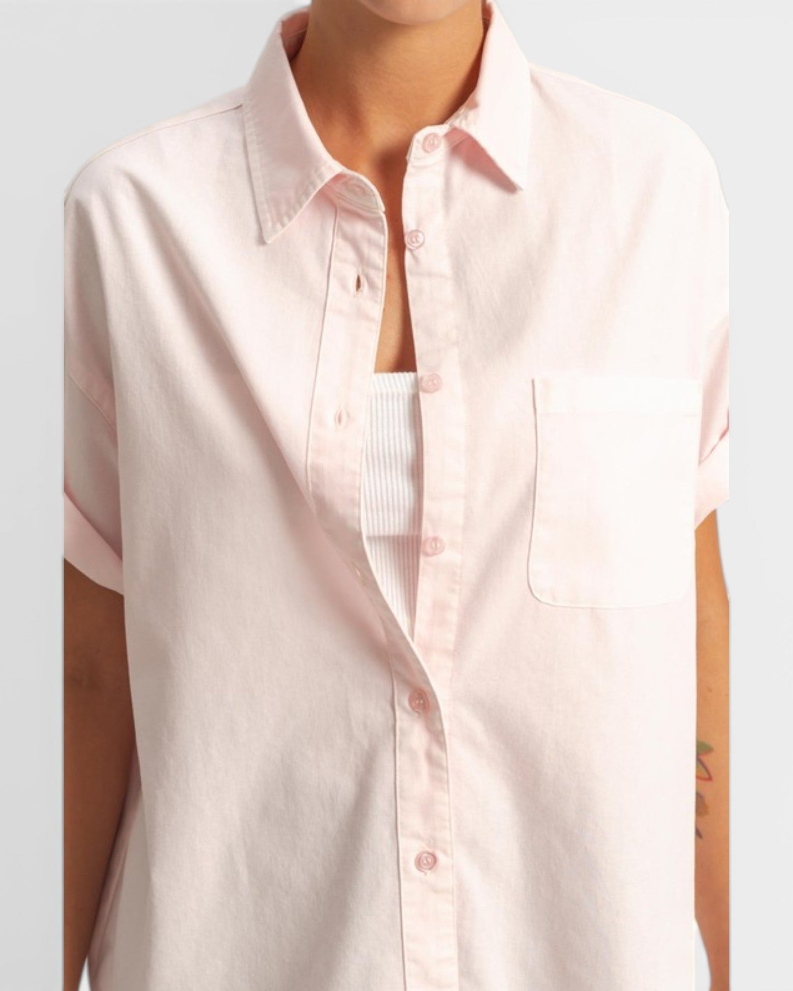 Light pink short-sleeve shirt worn by a person on a light gray background