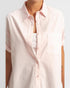 Light pink short-sleeve shirt worn by a person on a light gray background