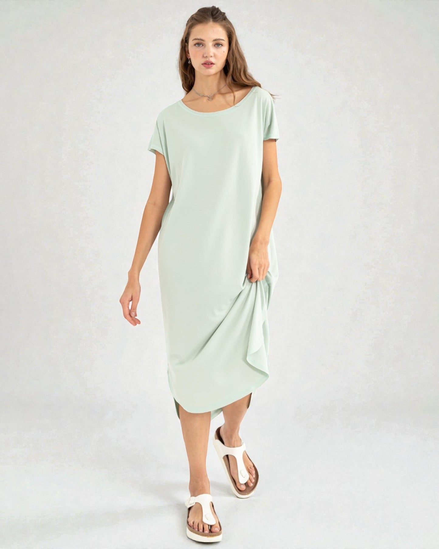 Woman wearing a light green dress on a white background