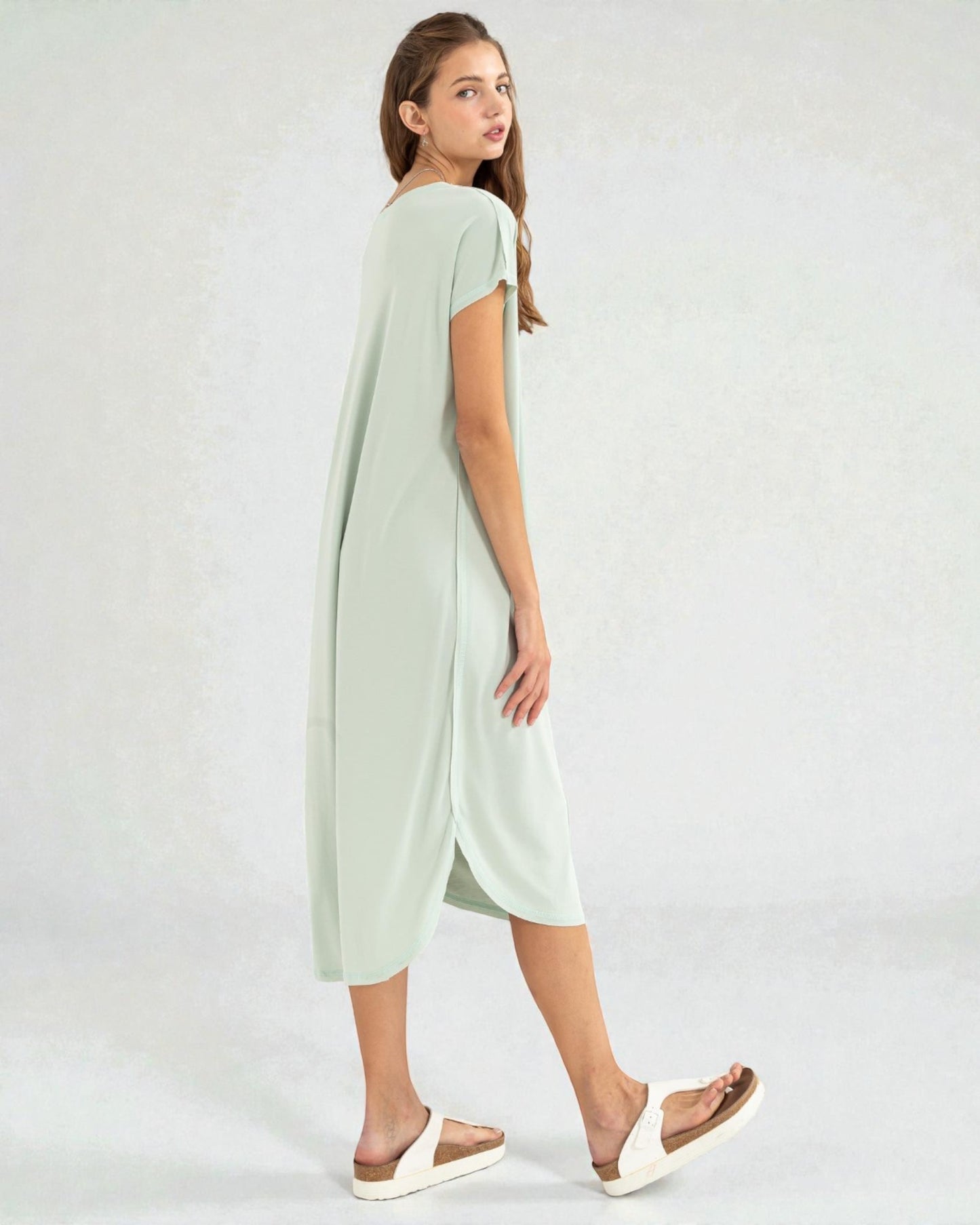 Woman wearing a light green dress on a white background