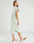 Woman wearing a light green dress on a white background