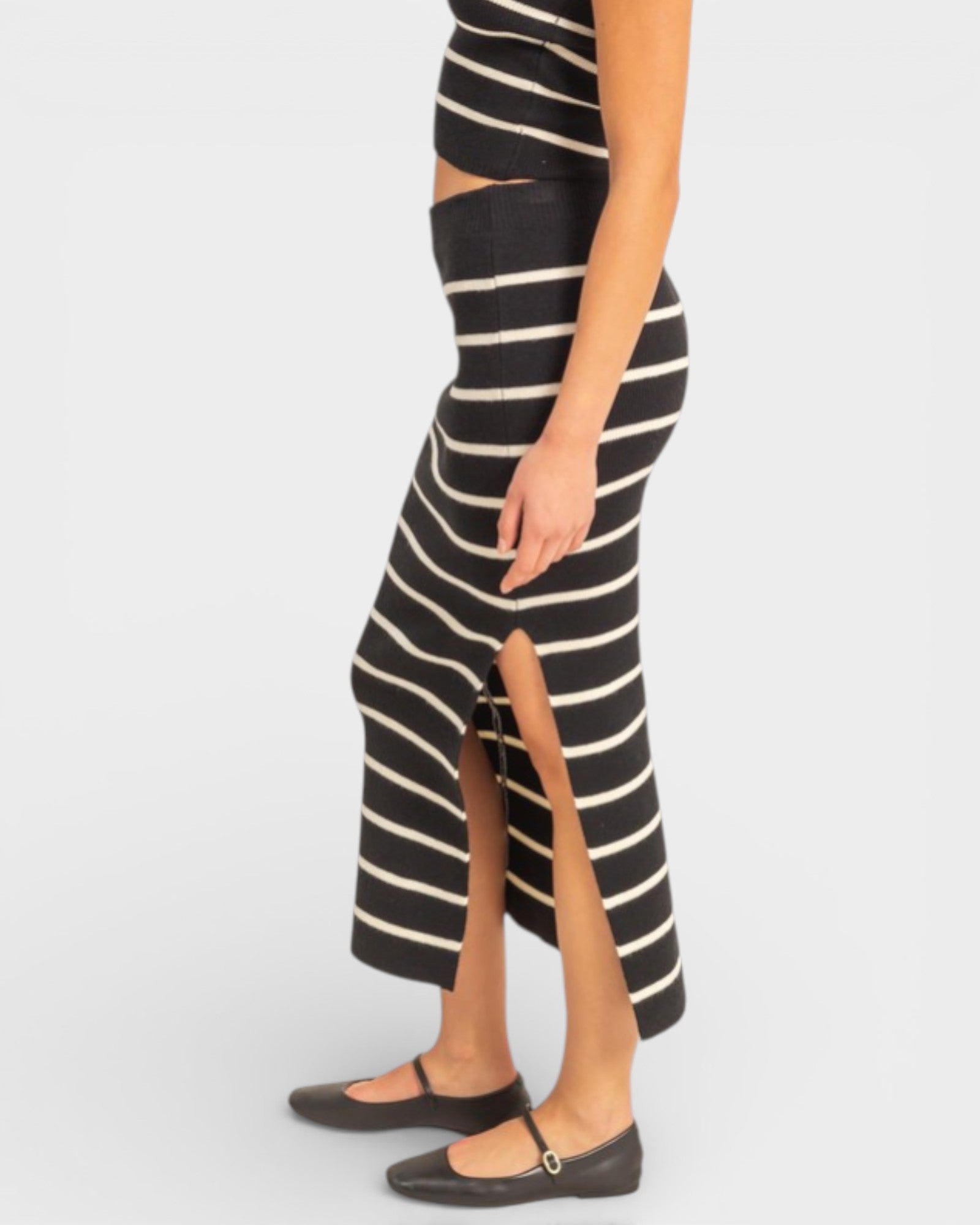 Black and white striped dress with a high slit on a plain background