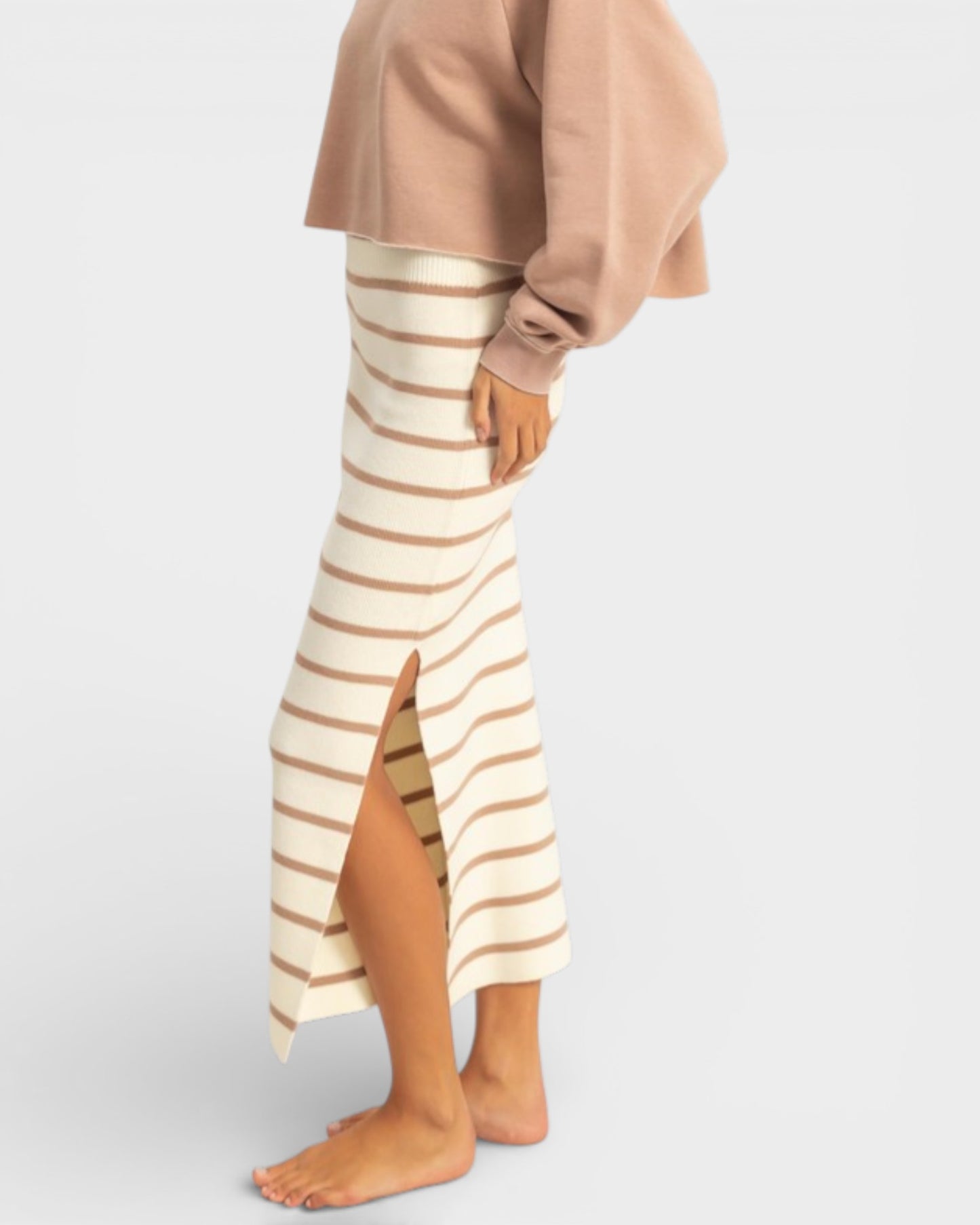 Person wearing a beige and brown striped skirt on a white background