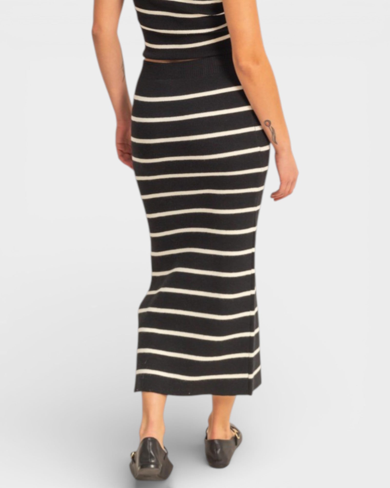 Black and white striped dress worn by a person on a plain background