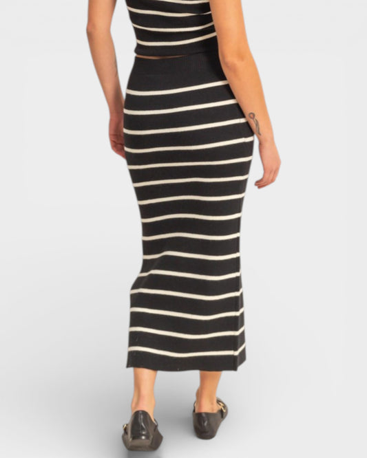 Black and white striped dress worn by a person on a plain background