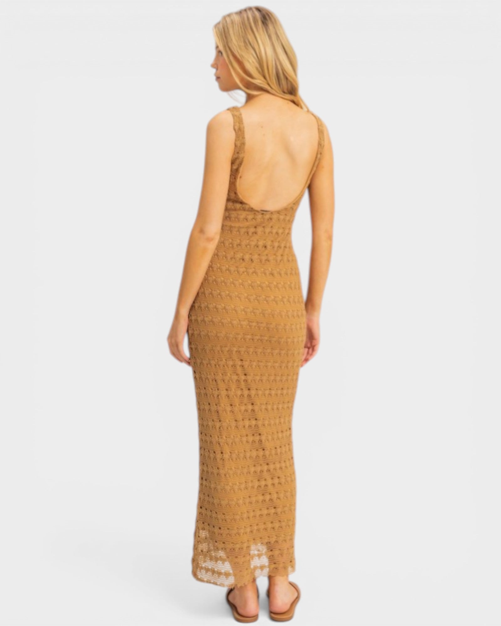 Woman wearing a mustard yellow lace dress on a white background