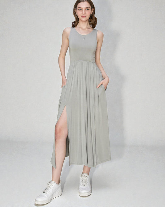 Woman wearing a light gray sleeveless dress with a slit on a white background