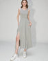 Woman wearing a light gray sleeveless dress with a slit on a white background