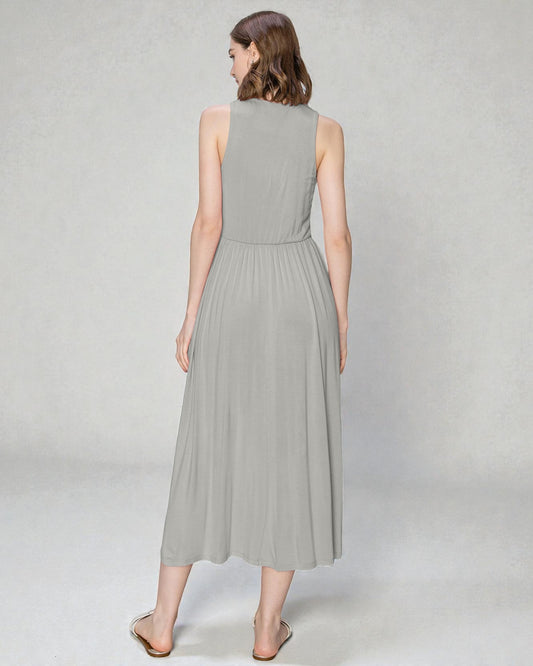 Woman wearing a light gray sleeveless dress on a plain background