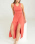 Woman wearing a coral dress with a slit on a white background