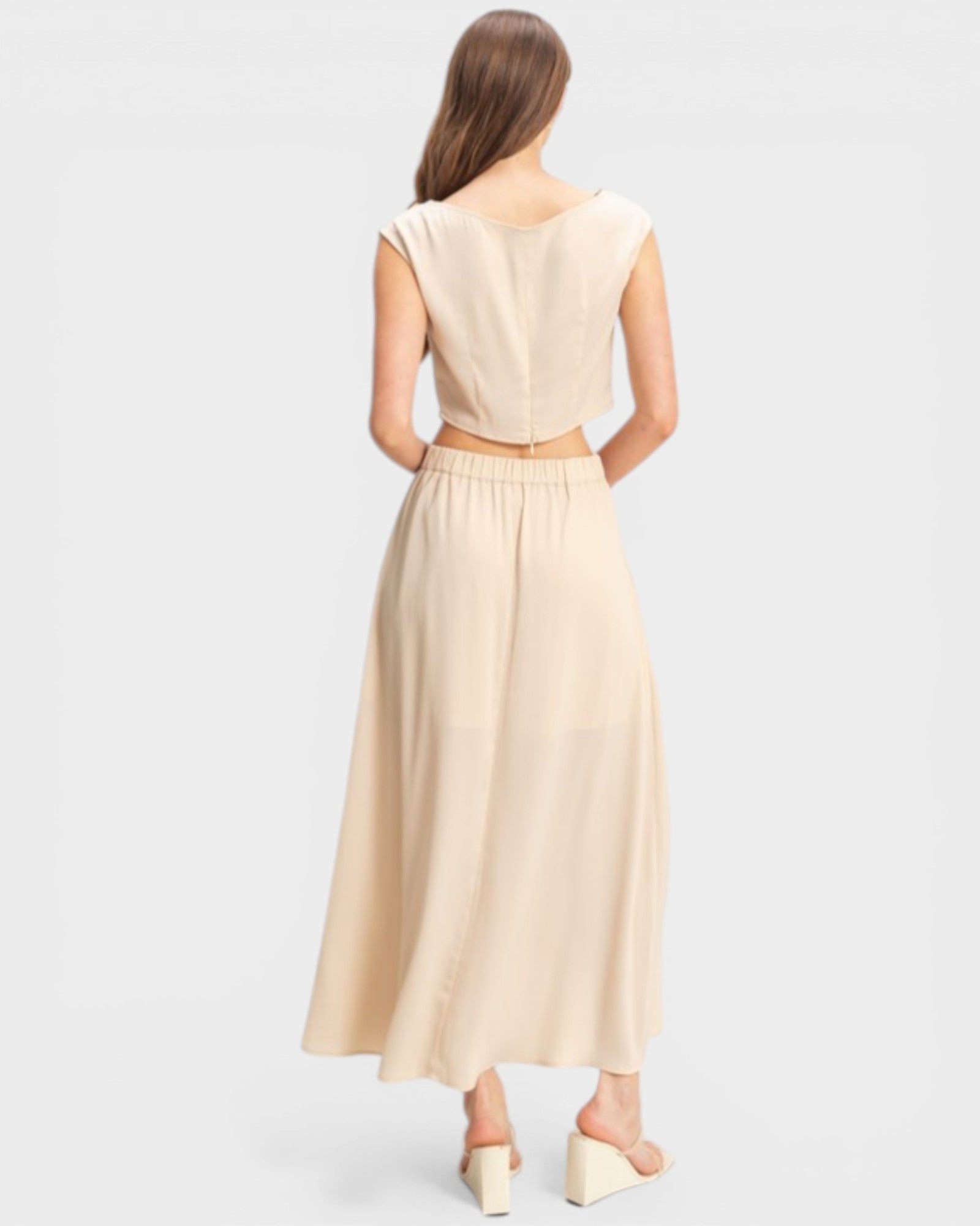 Woman wearing a beige dress on a light gray background