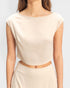 Beige sleeveless top with a copper belt on a plain background
