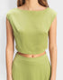 Green sleeveless top worn by a person on a white background