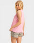 Woman wearing a pink sleeveless top and denim shorts on a white background