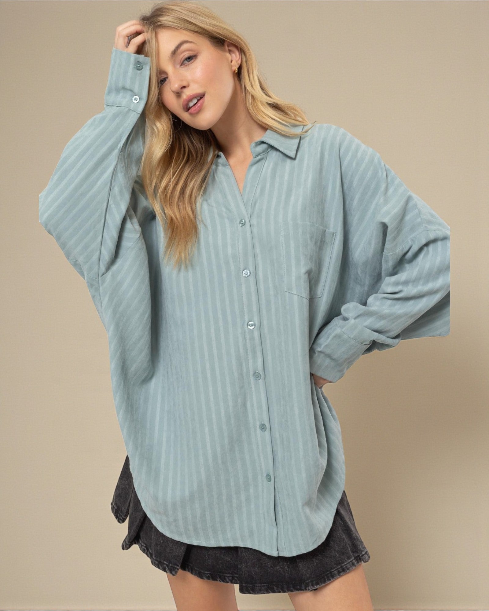 Woman wearing a light blue striped shirt with a beige background