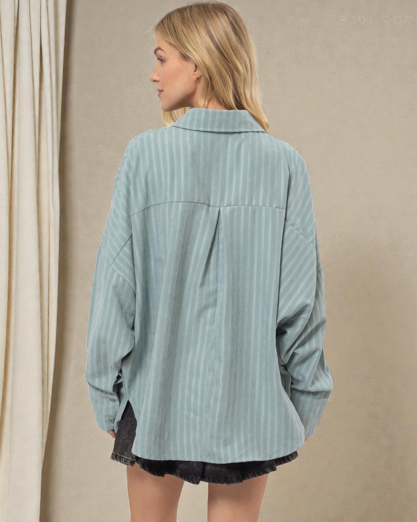 Woman wearing a light blue corduroy shirt against a beige background