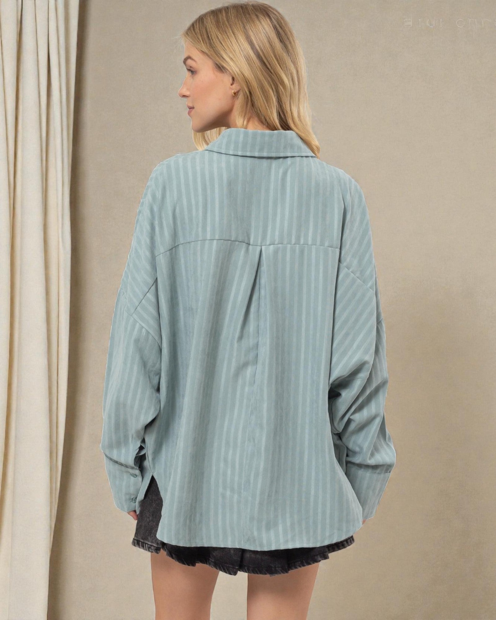 Woman wearing a light blue corduroy shirt against a beige background