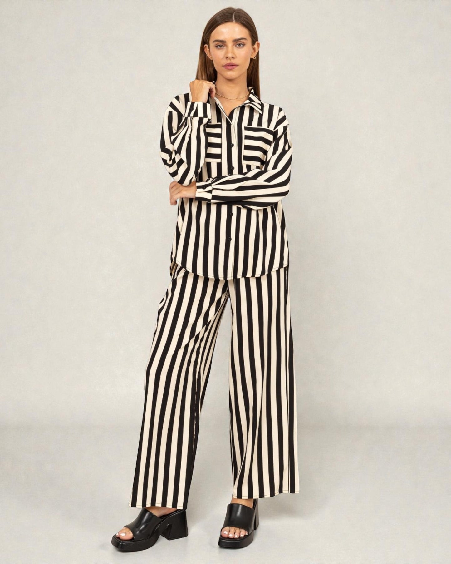 Woman wearing a black and white striped outfit on a plain background