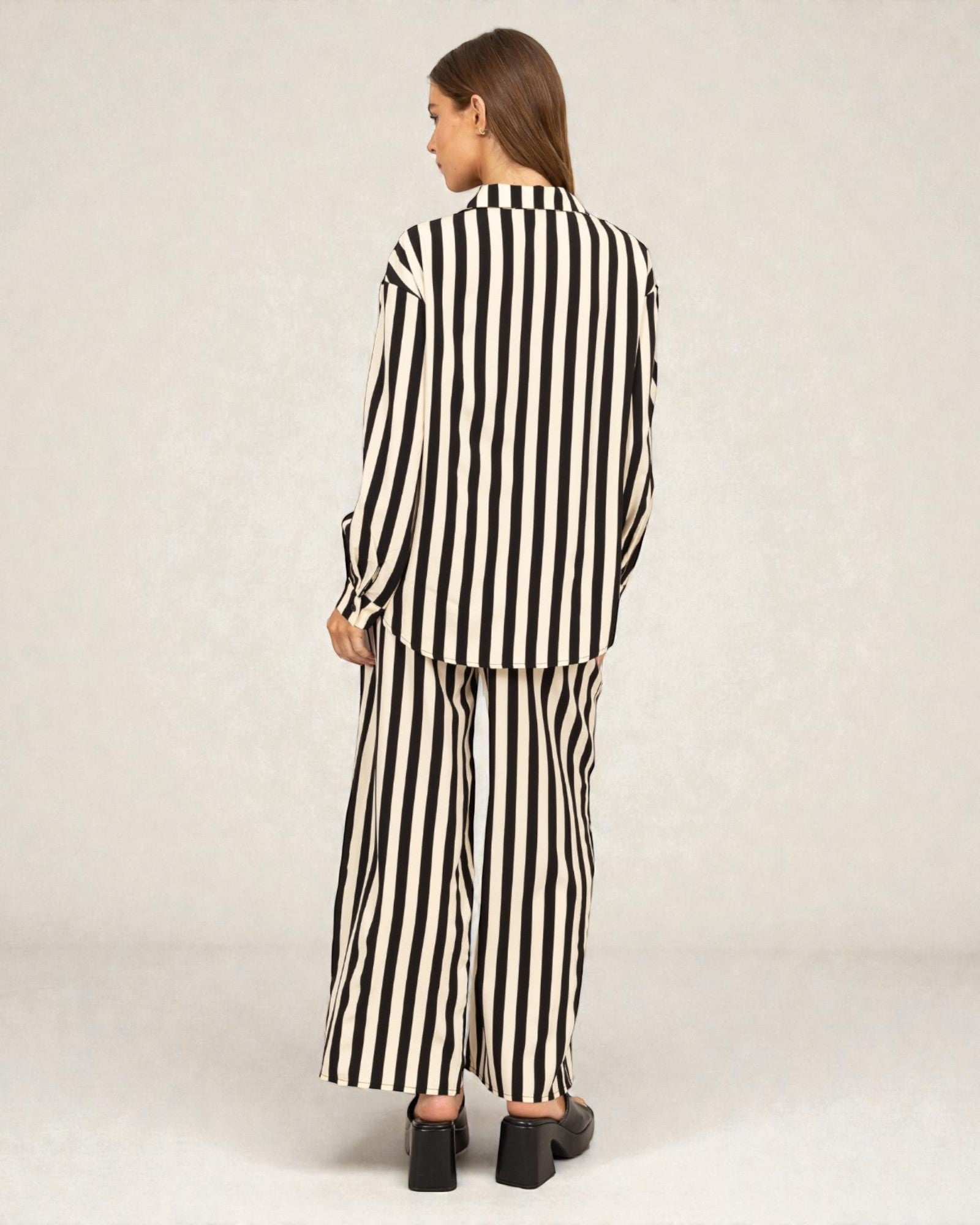 Person wearing a black and white striped outfit on a plain background