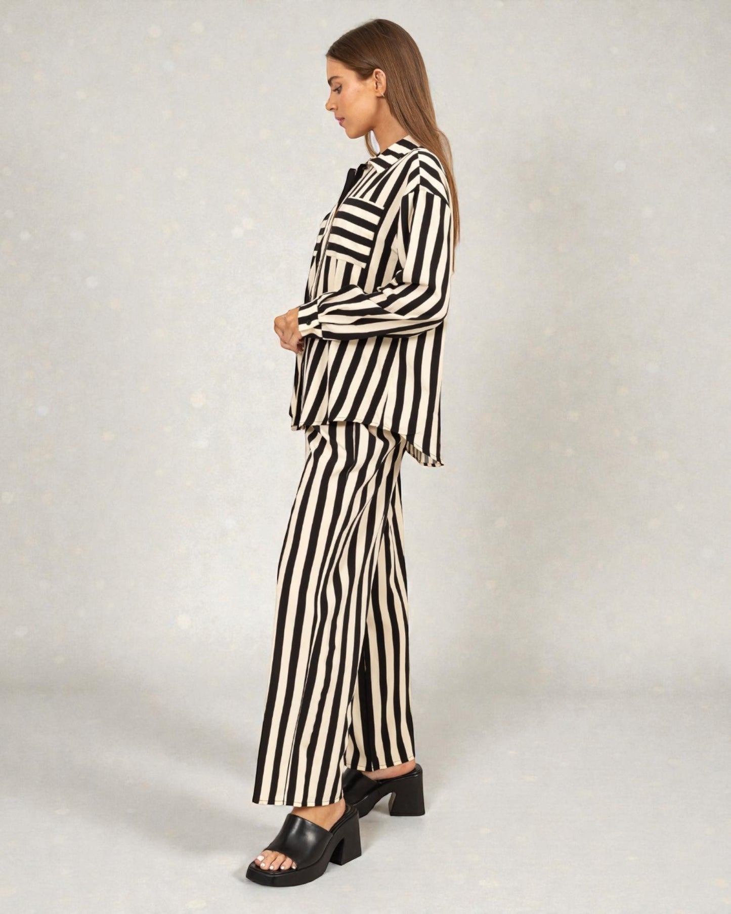 Woman wearing a black and white striped outfit on a plain background