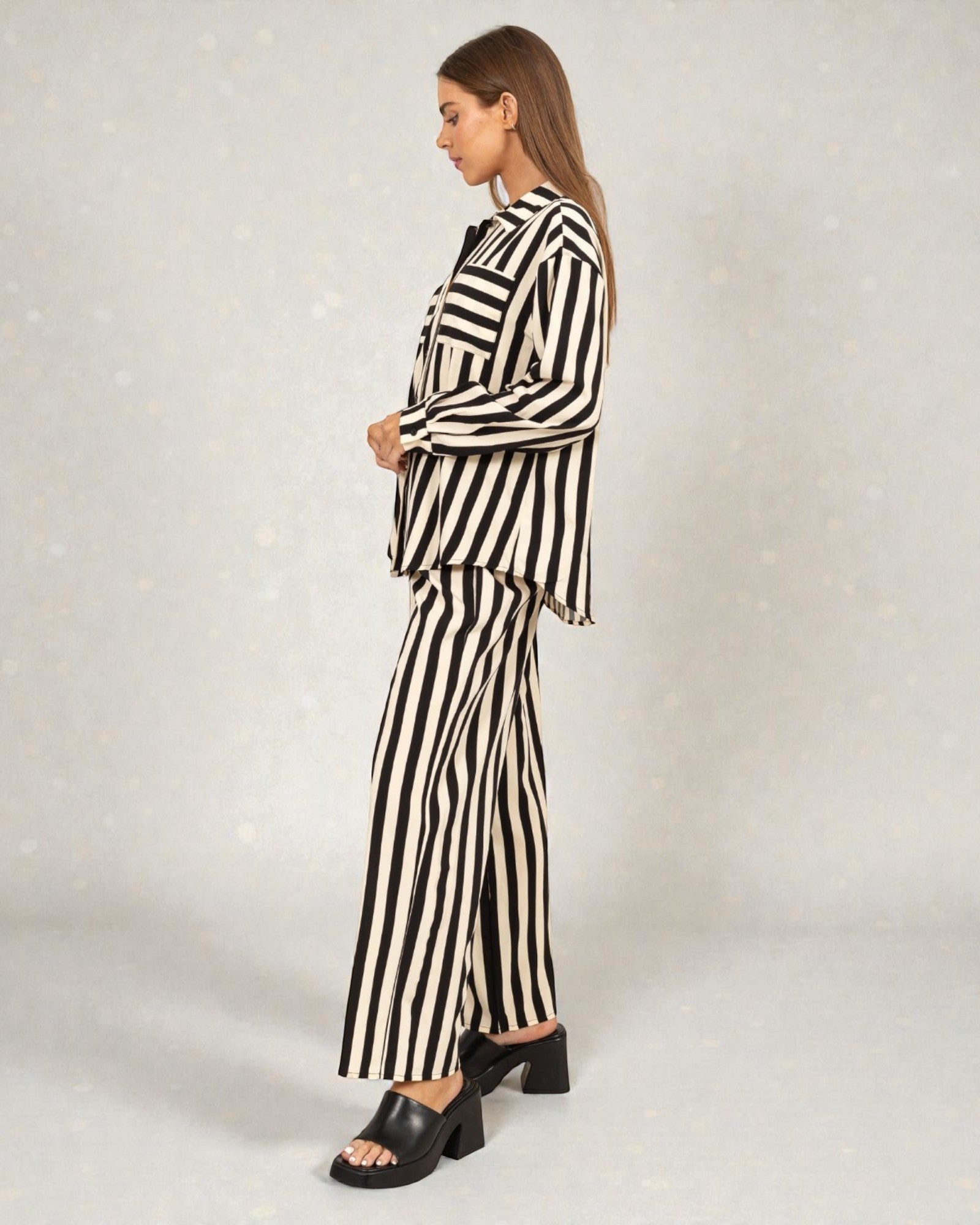 Woman wearing a black and white striped outfit on a plain background