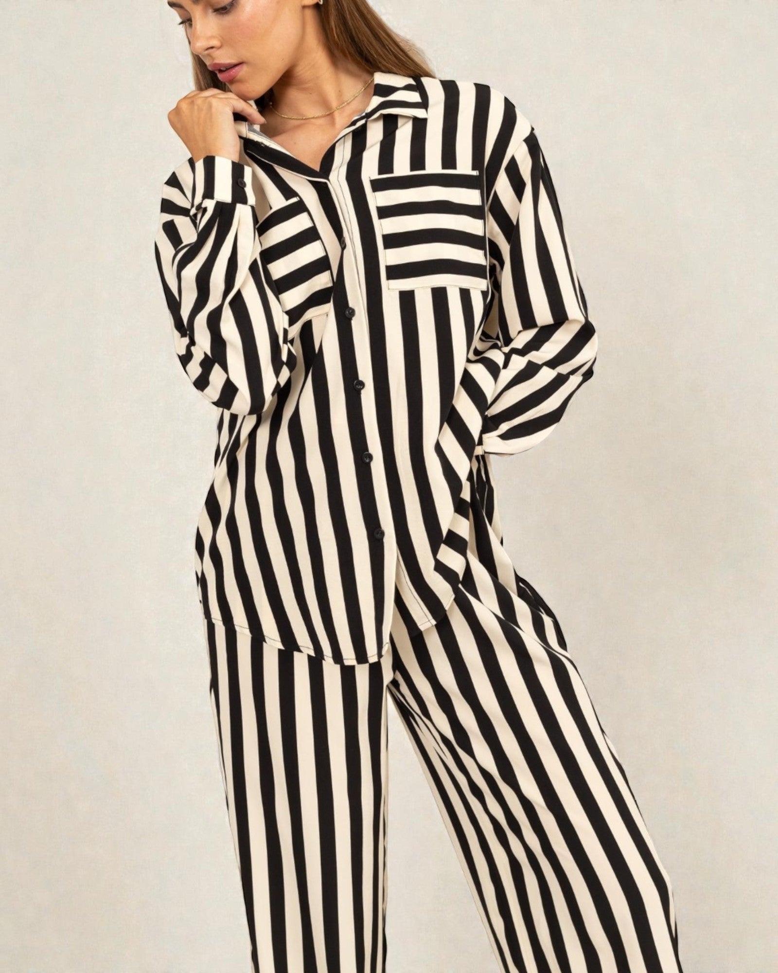 Woman wearing a black and white striped outfit on a plain background