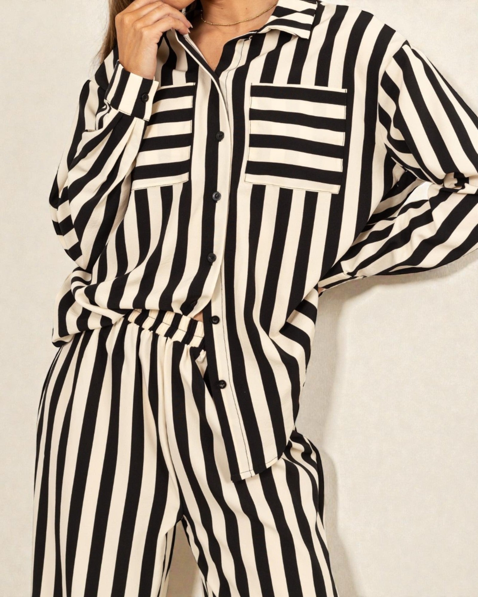 Black and white striped jumpsuit on a plain background