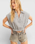 Woman wearing a striped shirt and shorts on a plain background