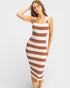 Woman wearing a brown and white striped dress on a plain background