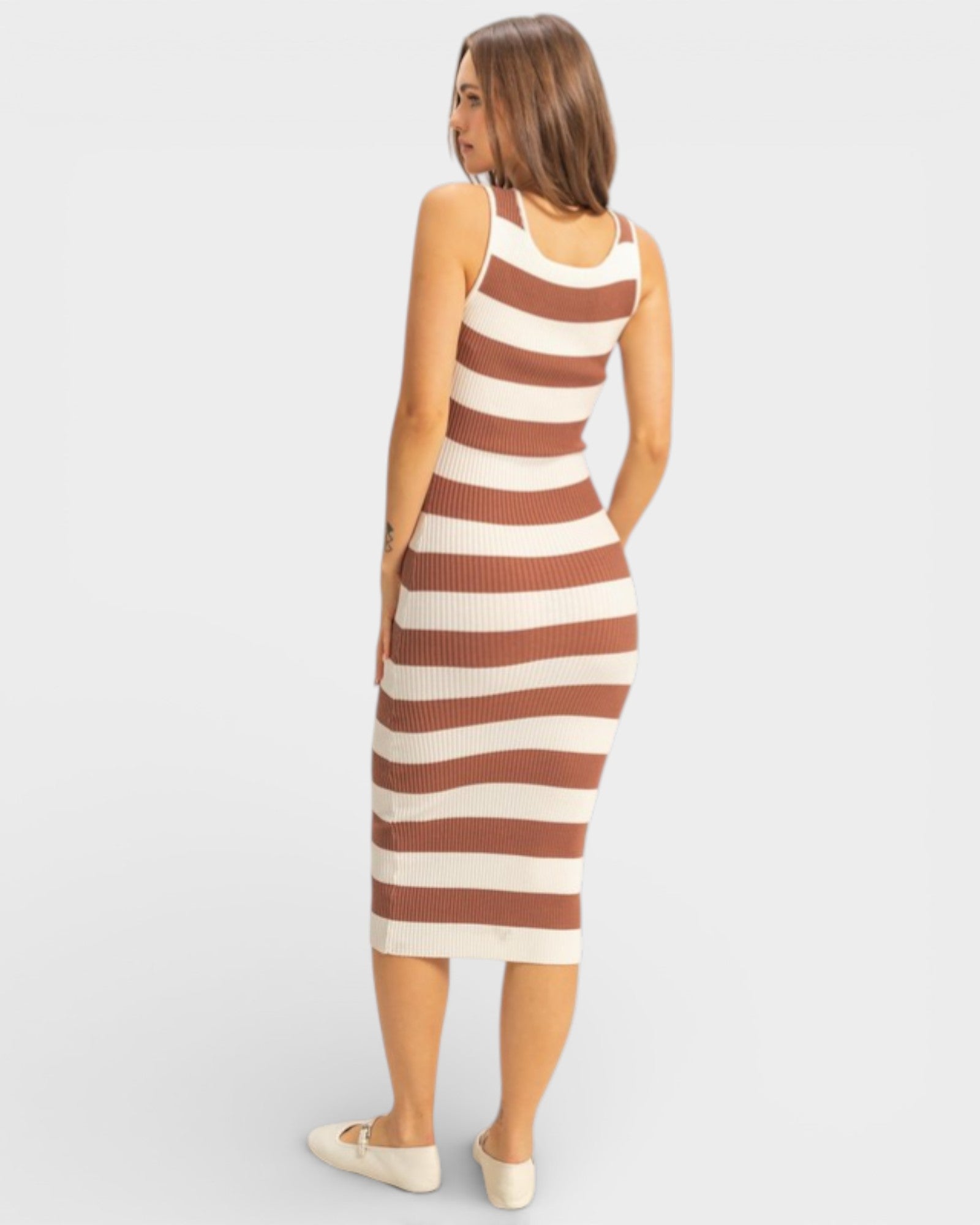 Woman wearing a brown and beige striped dress on a white background