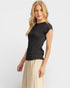 Woman wearing a black top and beige pants on a white background