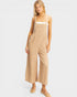 Woman wearing a beige jumpsuit on a white background