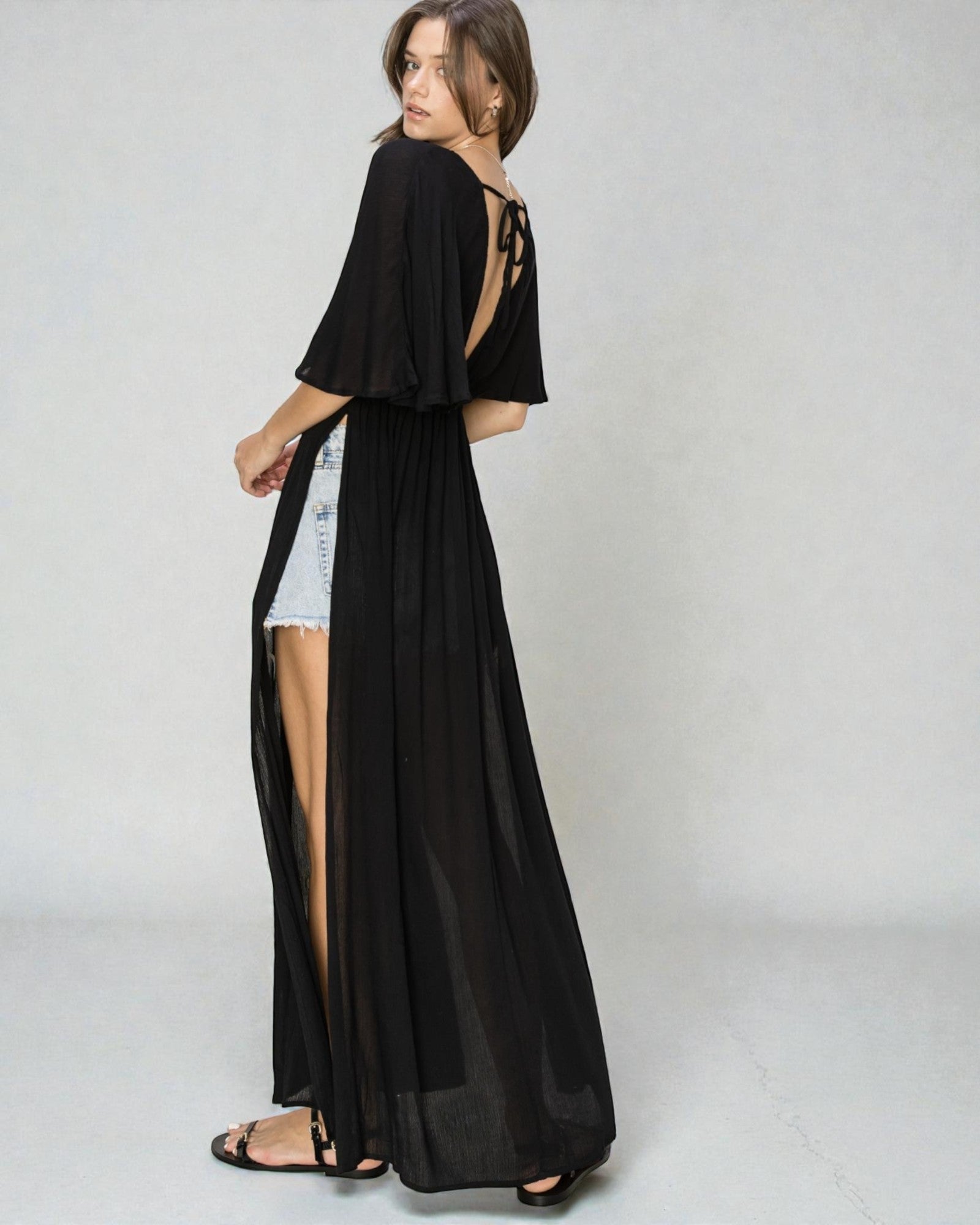 Woman wearing a black long dress with a white background