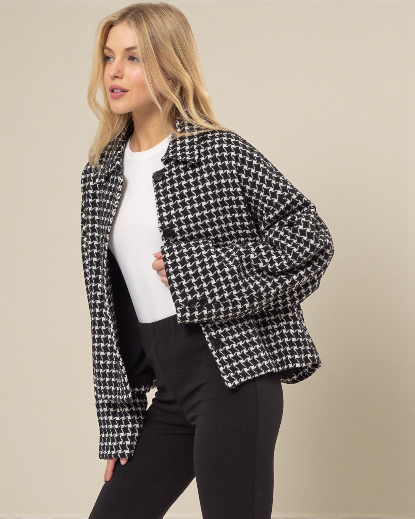 Woman wearing a black and white checkered jacket on a beige background