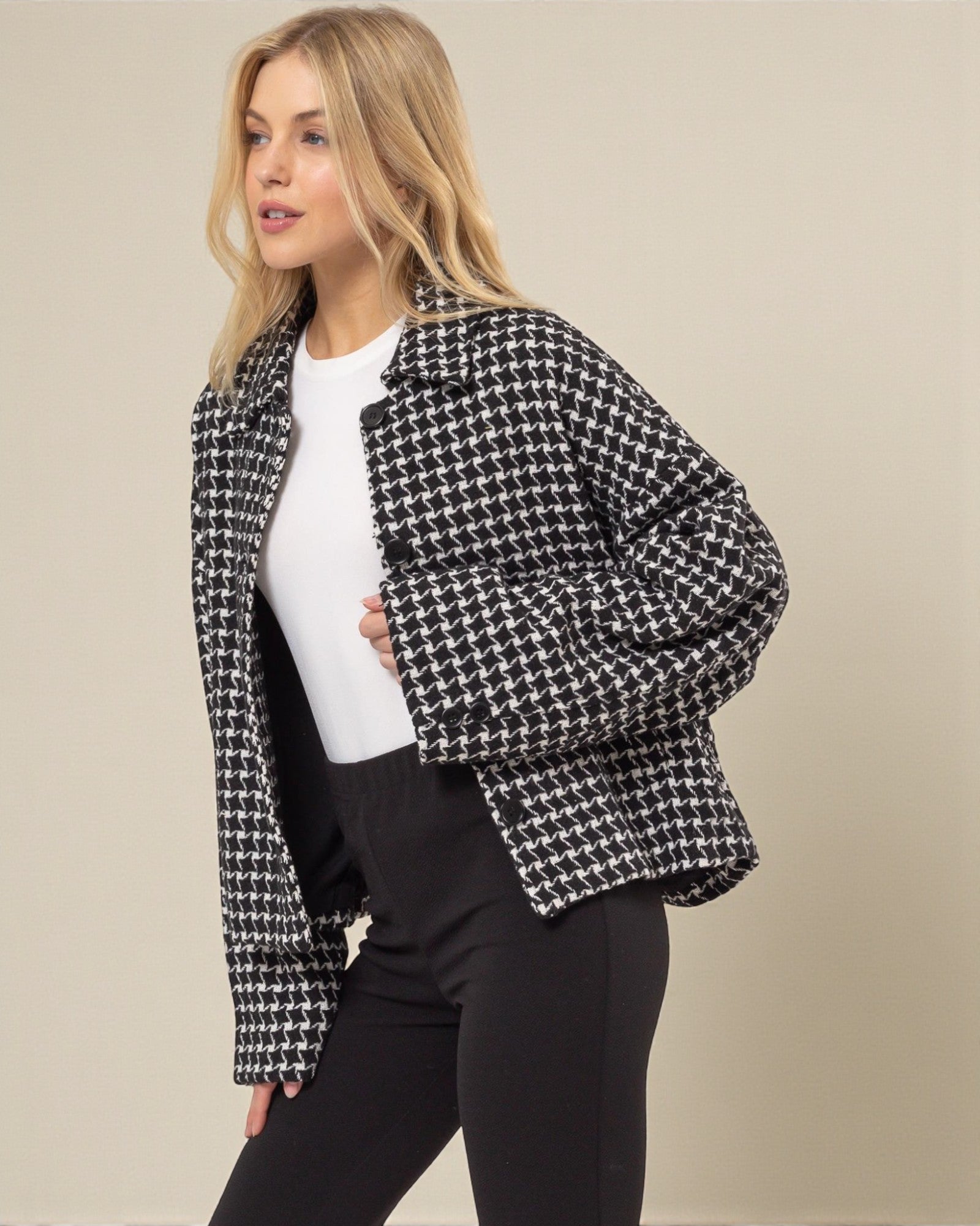 Woman wearing a black and white checkered jacket on a beige background