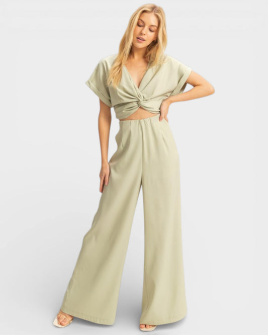 Woman wearing a light green jumpsuit on a white background